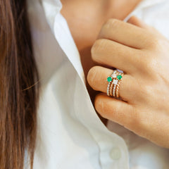 White gold braided ring with central emerald